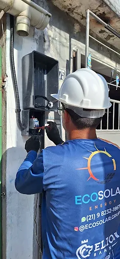 Técnico da EcoSolar, com uniforme azul-marinho da marca, fazendo a instalação elétrica de um sistema fotovoltaico